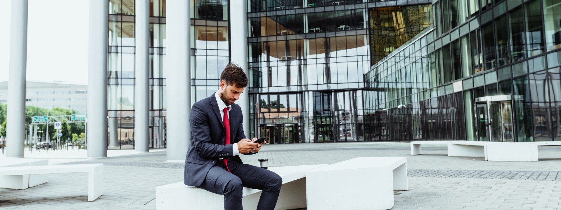 man using phone outside a business building