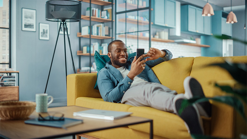 man on sofa using mobile