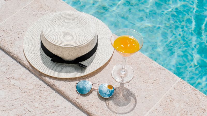 hat and drink by the pool